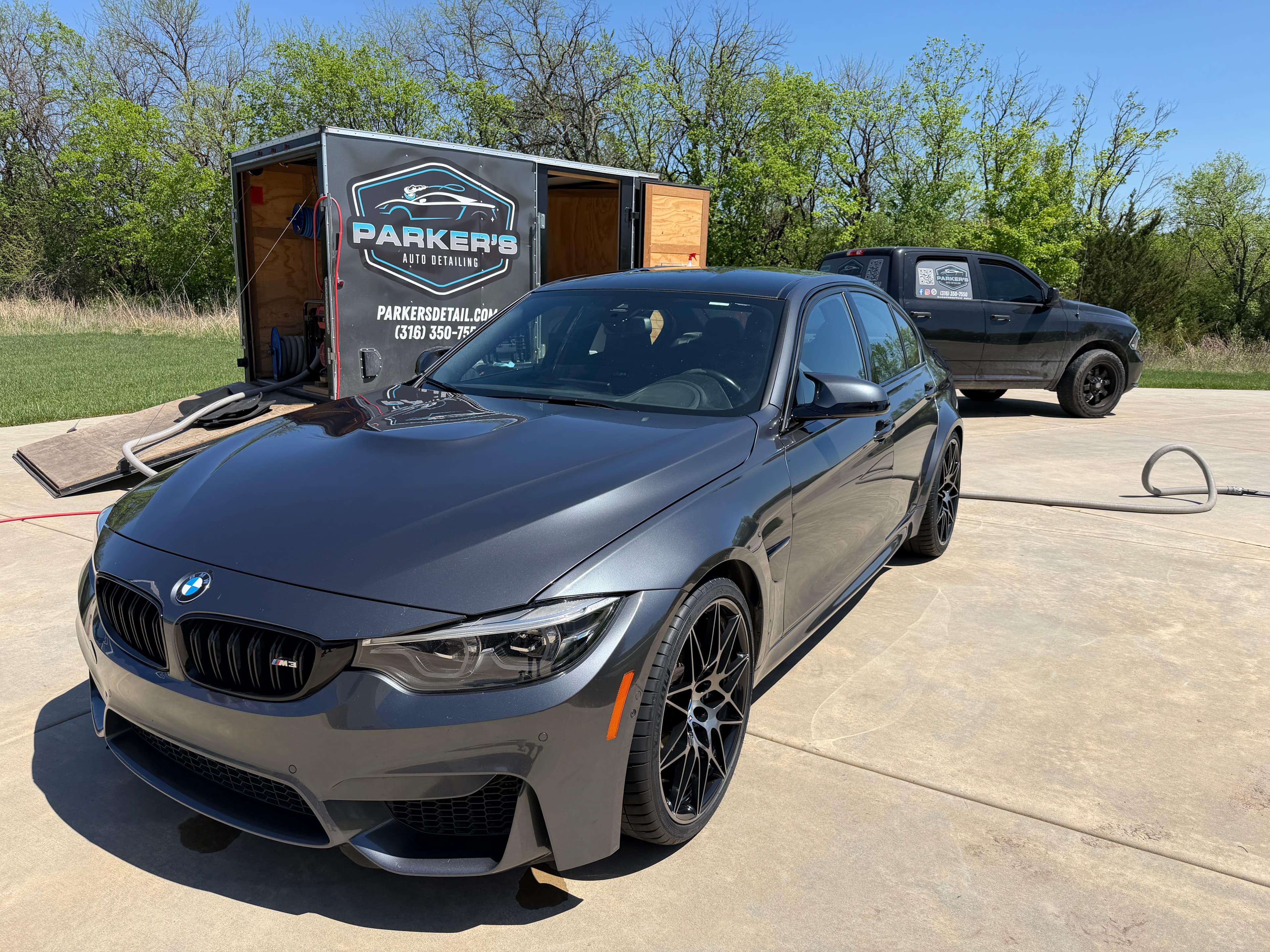 Professional car detailer washing vehicle exterior at Parker's Detail Wichita KS